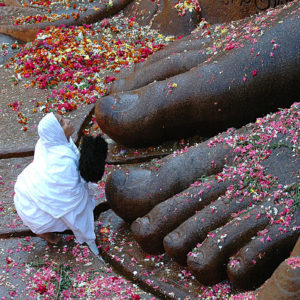 A female monk at the feet of the Jain statue of Bahubali in Sravanabelagola, India