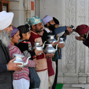 Devotees drinking amrit or holy water in the Bangla Sahib Temple sikh, Delhi, India